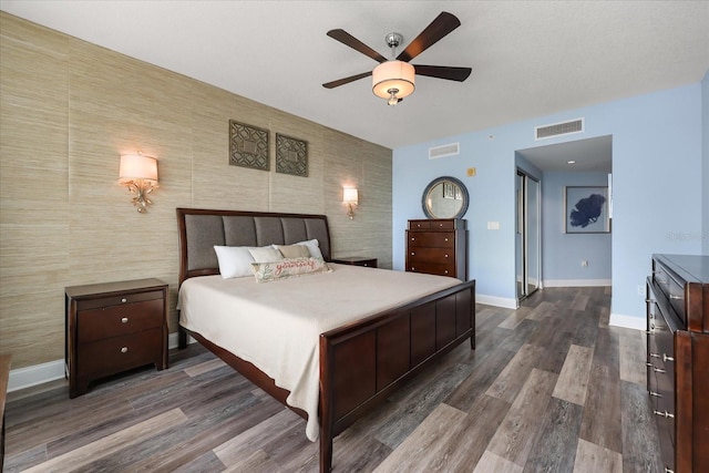 241 Riverside Dr Unit 902, Holly Hill, FL 32117 - bedroom featuring an accent wall, dark wood-style floors, and a ceiling fan