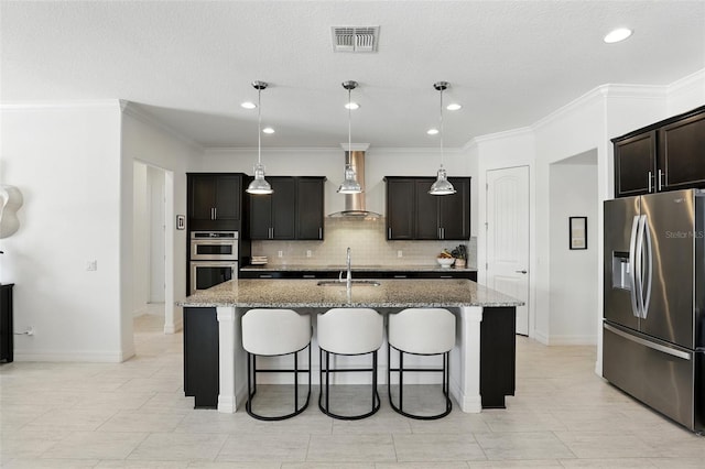 2118 Whiting Trl, Orlando, FL 32820 - kitchen with appliances with stainless steel finishes, wall chimney range hood, a breakfast bar, decorative backsplash, and a kitchen island with sink