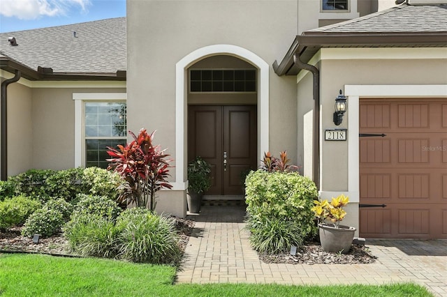 2118 Whiting Trl, Orlando, FL 32820 - view of exterior entry featuring stucco siding and roof with shingles
