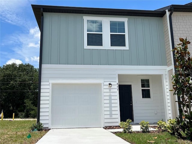 477 Madison Dr, Davenport, FL 33837 - view of front of property with board and batten siding, a garage, and driveway