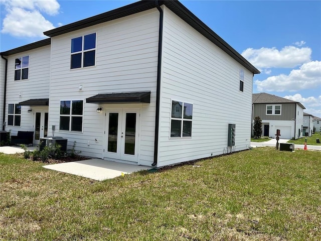 477 Madison Dr, Davenport, FL 33837 - rear view of property with french doors, central air condition unit, a lawn, and a patio area