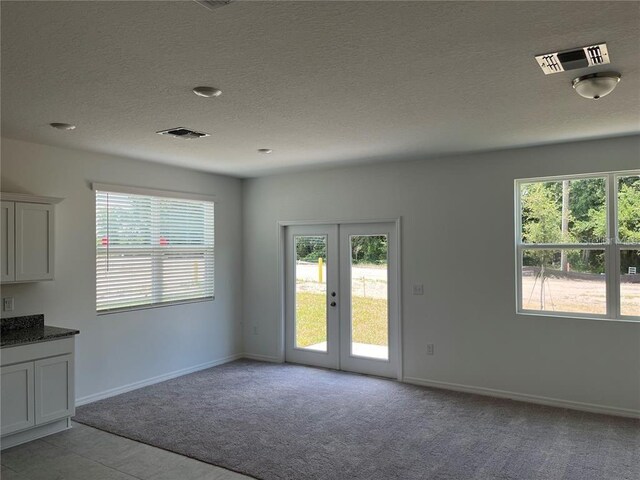 477 Madison Dr, Davenport, FL 33837 - unfurnished dining area with french doors, healthy amount of natural light, light carpet, baseboards, and a textured ceiling