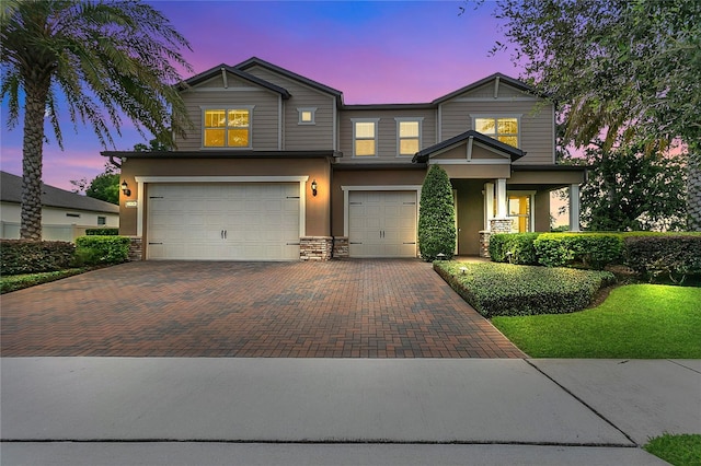 1938 Filly Trl, Oviedo, FL 32765 - view of front facade featuring an attached garage, decorative driveway, stone siding, and stucco siding