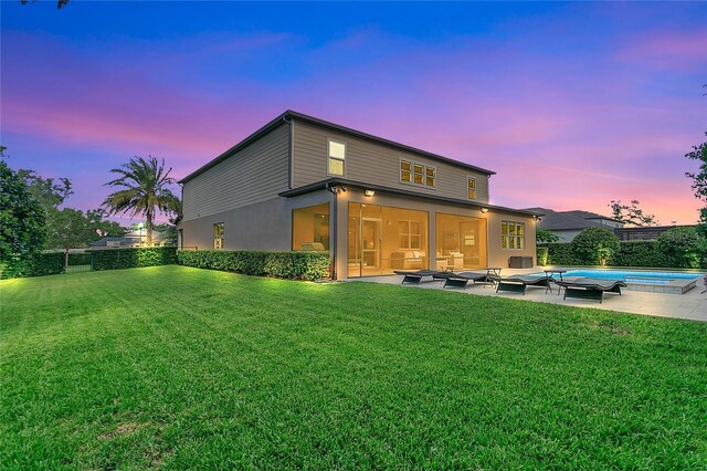 1938 Filly Trl, Oviedo, FL 32765 - back of house at dusk featuring a sunroom, a patio, an outdoor living space, and a fenced backyard