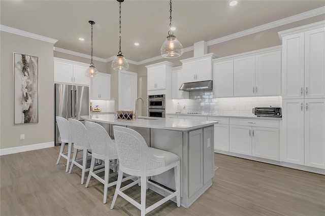 1938 Filly Trl, Oviedo, FL 32765 - kitchen featuring stainless steel appliances, a kitchen island with sink, a kitchen bar, backsplash, and ornamental molding