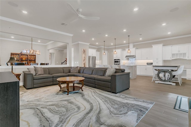 1938 Filly Trl, Oviedo, FL 32765 - living area featuring light wood-type flooring, ceiling fan, stairs, recessed lighting, and crown molding