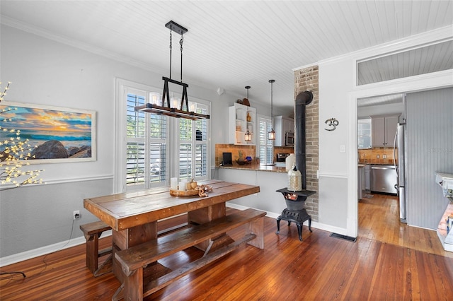 6501 Matchett Rd, Belle Isle, FL 32809 - dining area featuring a wood stove, hardwood / wood-style flooring, and crown molding
