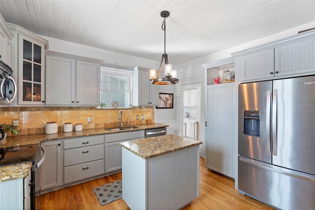 6501 Matchett Rd, Belle Isle, FL 32809 - kitchen featuring stainless steel appliances, backsplash, glass insert cabinets, and light wood-style flooring