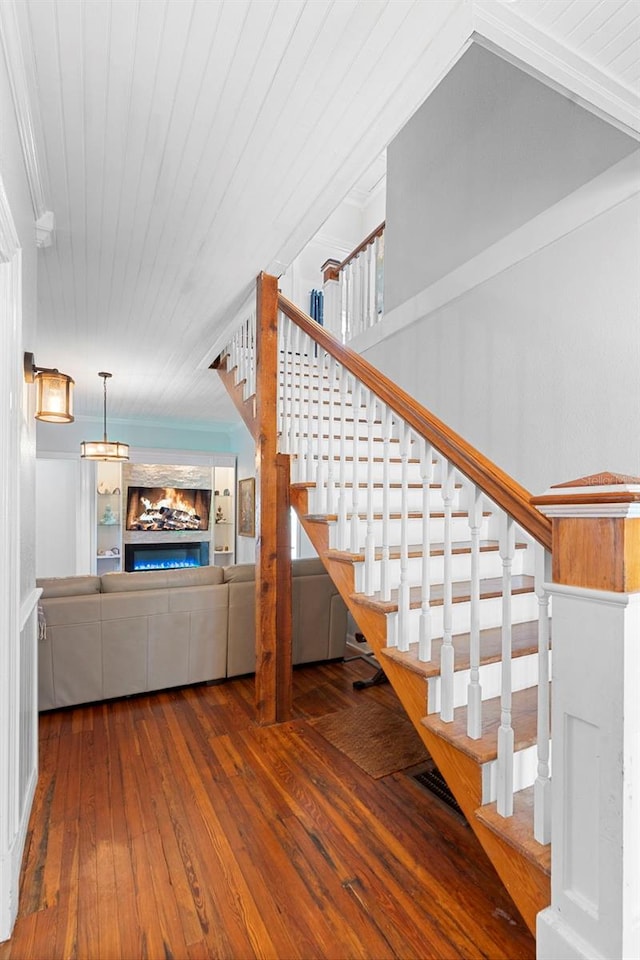 6501 Matchett Rd, Belle Isle, FL 32809 - staircase with hardwood / wood-style floors and a lit fireplace
