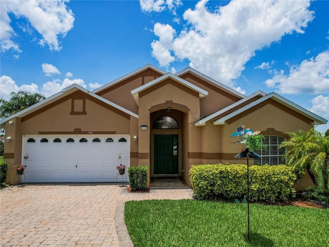 456 Old Bridge Cir, Davenport, FL 33897 - view of front of house featuring stucco siding, a garage, decorative driveway, and a front lawn