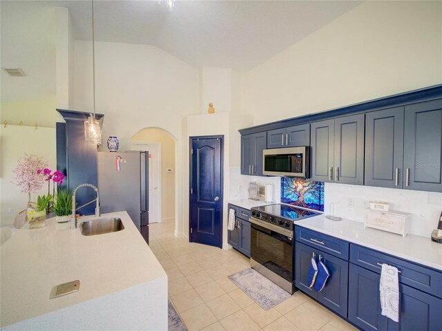 456 Old Bridge Cir, Davenport, FL 33897 - kitchen featuring appliances with stainless steel finishes, light tile patterned floors, arched walkways, light countertops, and high vaulted ceiling