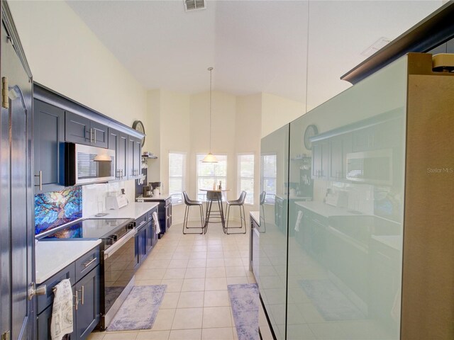 456 Old Bridge Cir, Davenport, FL 33897 - kitchen featuring appliances with stainless steel finishes, light tile patterned floors, light countertops, pendant lighting, and tasteful backsplash
