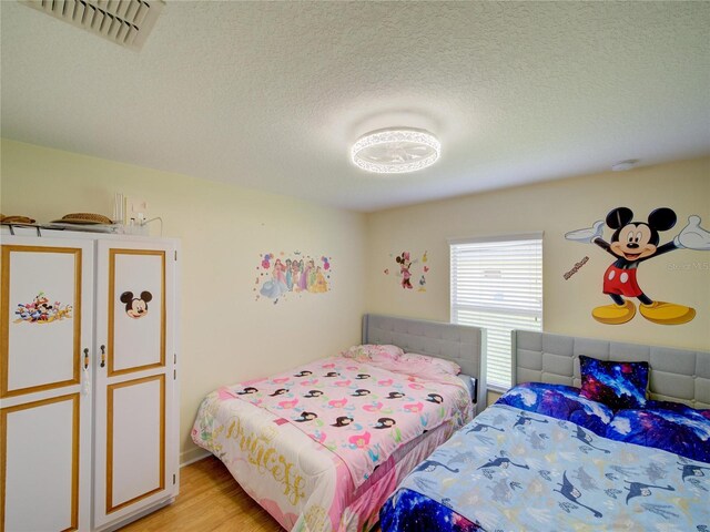 456 Old Bridge Cir, Davenport, FL 33897 - bedroom featuring light wood-style flooring and a textured ceiling
