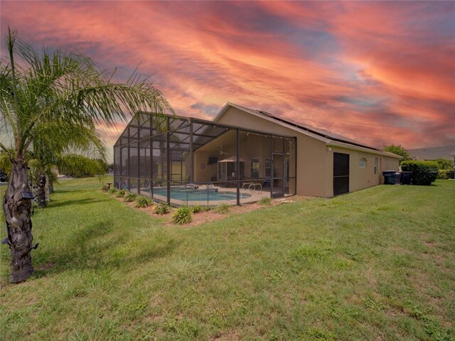 456 Old Bridge Cir, Davenport, FL 33897 - back of house featuring a yard, stucco siding, an outdoor pool, and glass enclosure