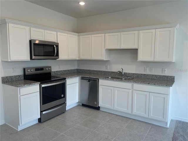 497 Madison Dr, Davenport, FL 33837 - kitchen featuring appliances with stainless steel finishes, white cabinetry, a sink, dark stone countertops, and recessed lighting