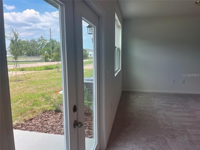 497 Madison Dr, Davenport, FL 33837 - doorway to outside featuring carpet, healthy amount of natural light, and baseboards