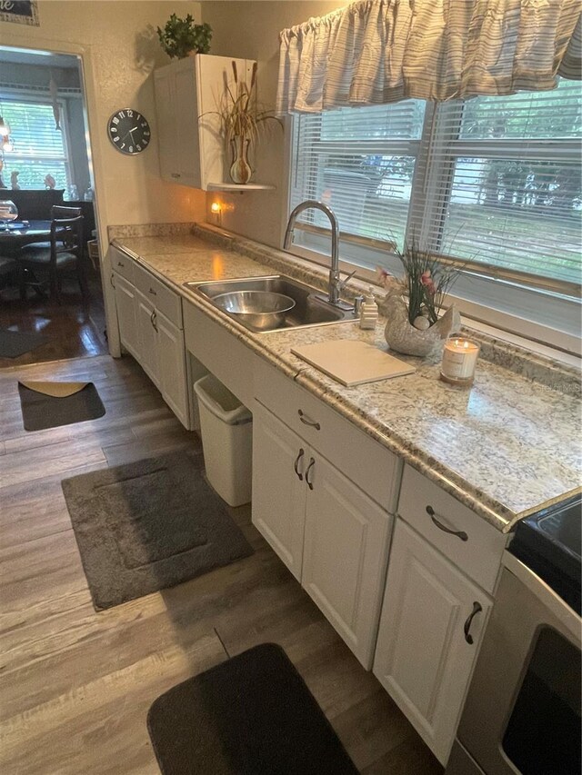 578 3rd St, Daytona Beach, FL 32117 - kitchen featuring dark wood finished floors, white cabinetry, and light countertops