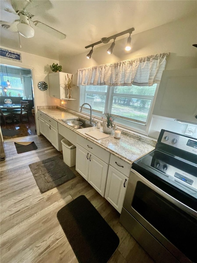 578 3rd St, Daytona Beach, FL 32117 - kitchen featuring electric range, white cabinets, light countertops, and dark wood finished floors