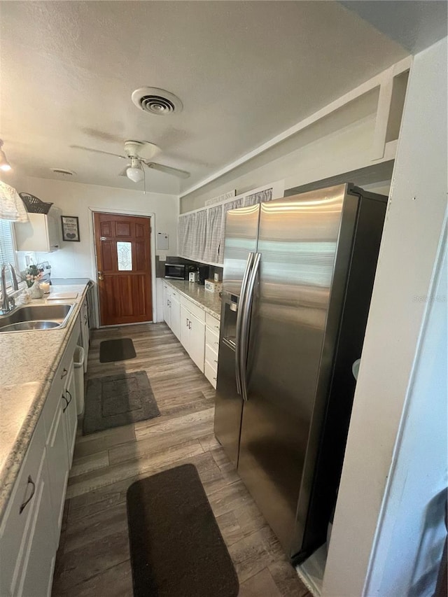 578 3rd St, Daytona Beach, FL 32117 - kitchen with stainless steel appliances, white cabinets, dark wood-type flooring, ceiling fan, and light countertops