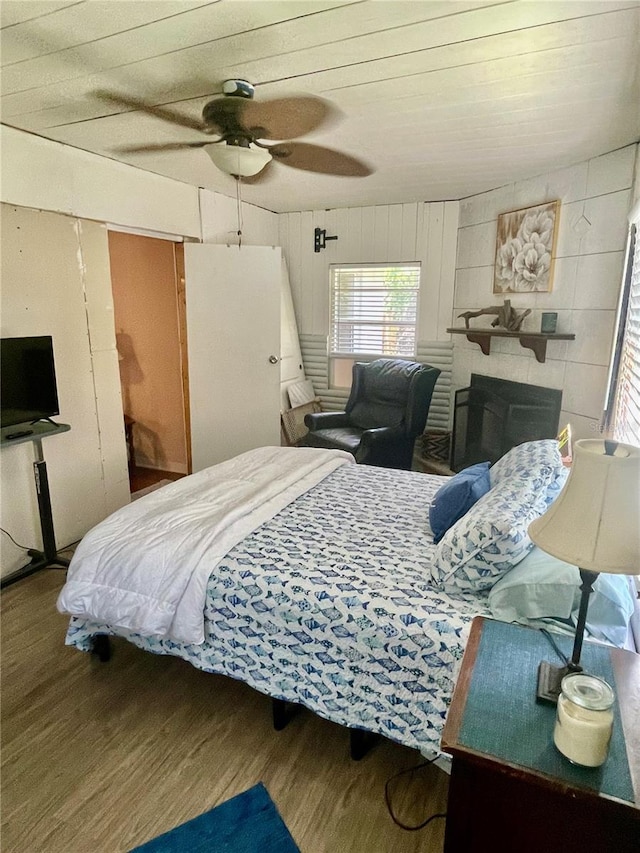 578 3rd St, Daytona Beach, FL 32117 - bedroom featuring wood finished floors, ceiling fan, wooden walls, wood ceiling, and a fireplace