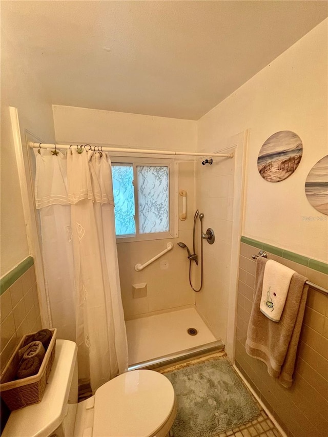 578 3rd St, Daytona Beach, FL 32117 - full bathroom featuring tile walls, a tile shower, and a wainscoted wall