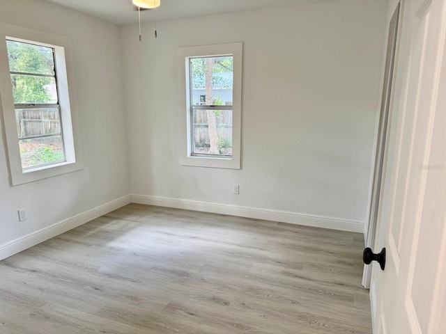38706 8th Ave, Zephyrhills, FL 33542 - unfurnished room with baseboards, plenty of natural light, and light wood finished floors