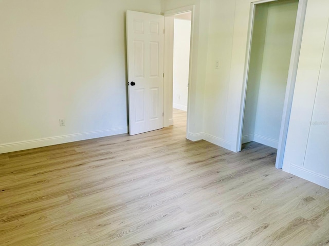 38706 8th Ave, Zephyrhills, FL 33542 - unfurnished bedroom featuring baseboards and light wood-type flooring