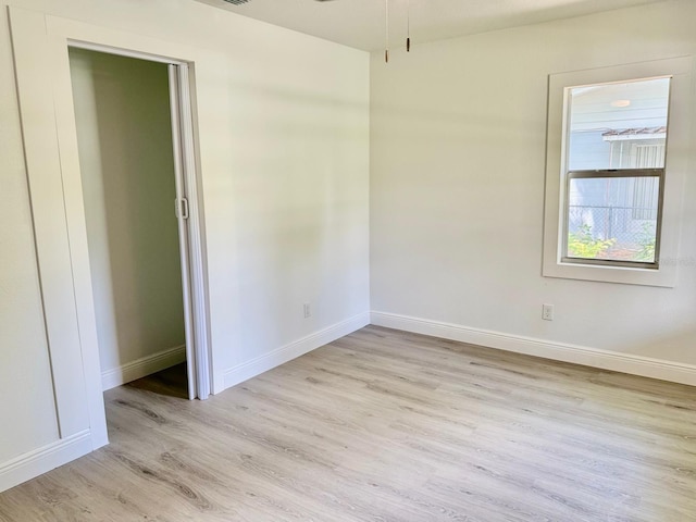 38706 8th Ave, Zephyrhills, FL 33542 - unfurnished bedroom with light wood-style floors and baseboards
