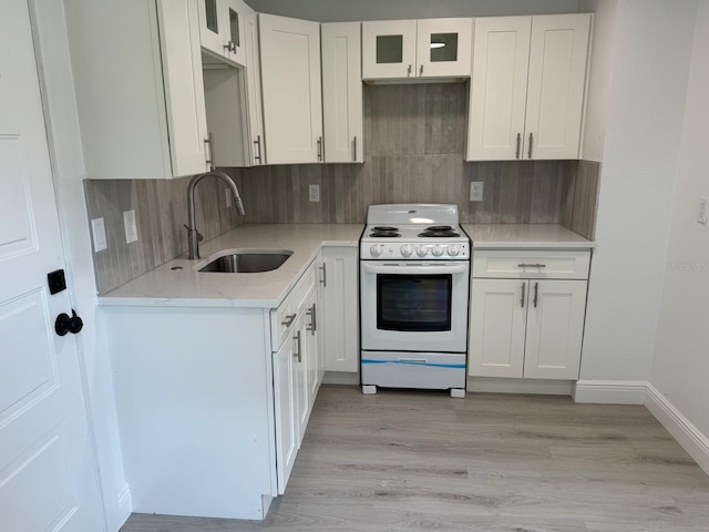 38706 8th Ave, Zephyrhills, FL 33542 - kitchen with electric range, a sink, tasteful backsplash, and white cabinetry