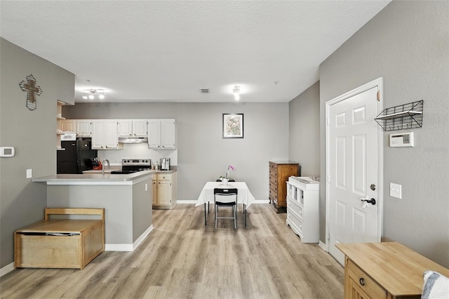 1125 Lake Shadow Cir Unit 5109, Maitland, FL 32751 - kitchen featuring freestanding refrigerator, light wood-style flooring, under cabinet range hood, white cabinets, and stainless steel electric range