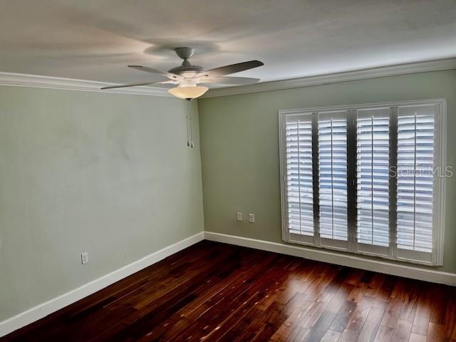 204 Quayside Cir Unit 601, Maitland, FL 32751 - spare room with ornamental molding, a ceiling fan, and dark wood-type flooring