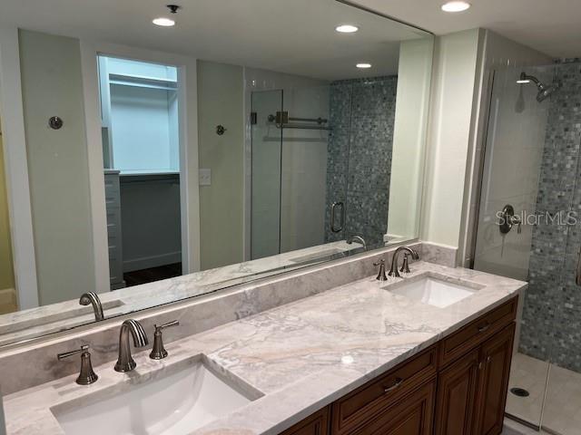 204 Quayside Cir Unit 601, Maitland, FL 32751 - full bathroom featuring a stall shower, double vanity, recessed lighting, and a spacious closet