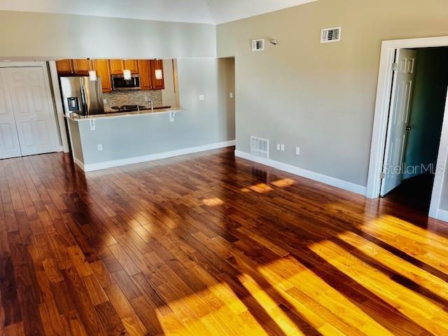204 Quayside Cir Unit 601, Maitland, FL 32751 - unfurnished living room with dark wood-style flooring and lofted ceiling