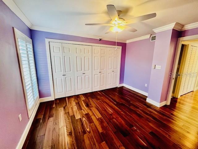 204 Quayside Cir Unit 601, Maitland, FL 32751 - unfurnished bedroom with wood finished floors, ornamental molding, ceiling fan, and a closet