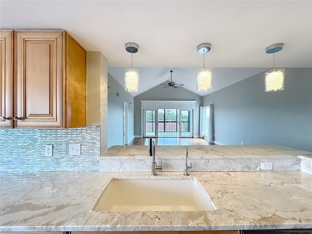 204 Quayside Cir Unit 601, Maitland, FL 32751 - kitchen featuring ceiling fan, backsplash, lofted ceiling, hanging light fixtures, and light stone counters