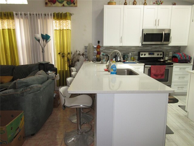 362 White Marsh Cir, Orlando, FL 32824 - kitchen featuring appliances with stainless steel finishes, a kitchen breakfast bar, open floor plan, a peninsula, and backsplash