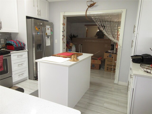362 White Marsh Cir, Orlando, FL 32824 - kitchen with stainless steel appliances, white cabinetry, light countertops, and a kitchen island