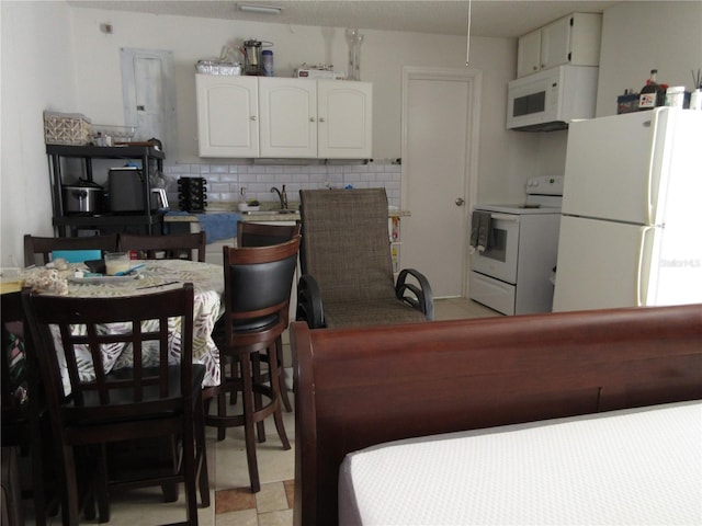 362 White Marsh Cir, Orlando, FL 32824 - kitchen with white appliances, white cabinetry, and backsplash