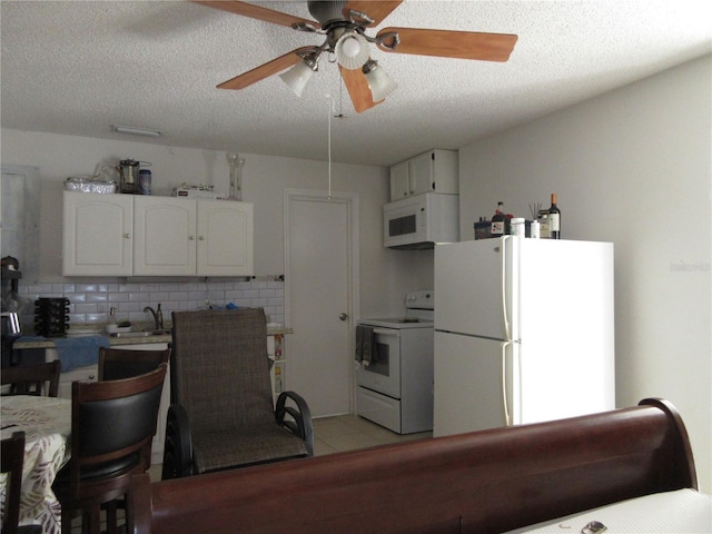 362 White Marsh Cir, Orlando, FL 32824 - kitchen with white appliances, a ceiling fan, a textured ceiling, white cabinets, and light tile patterned floors