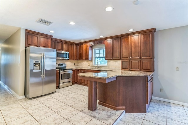 403 Broadview Ave, Altamonte Springs, FL 32701 - kitchen featuring stainless steel appliances, a peninsula, light stone counters, recessed lighting, and decorative backsplash