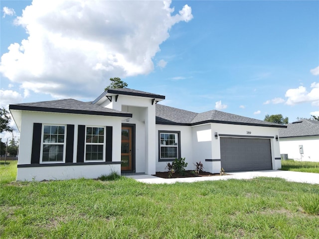 3159 SW 127th Lane Rd, Ocala, FL 34473 - prairie-style home with stucco siding, an attached garage, driveway, a front yard, and a shingled roof