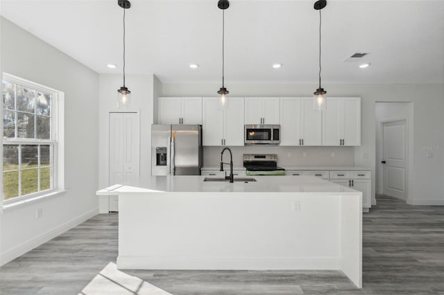 3159 SW 127th Lane Rd, Ocala, FL 34473 - kitchen featuring appliances with stainless steel finishes, a center island with sink, white cabinetry, light countertops, and recessed lighting