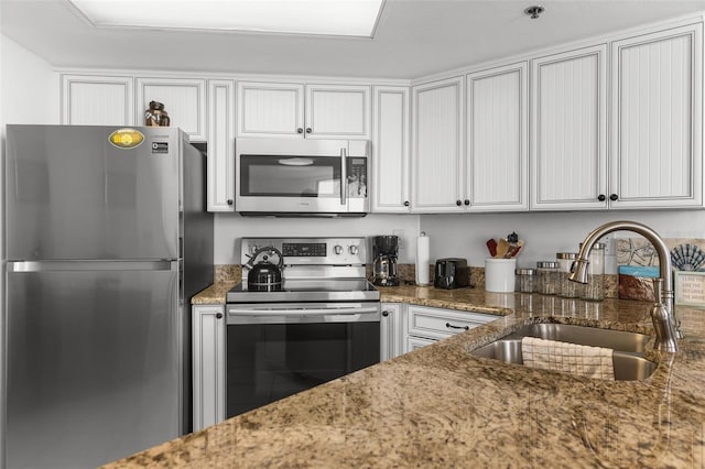 3023 S Atlantic Ave Unit 2050, Daytona Beach, FL 32118 - kitchen featuring appliances with stainless steel finishes, light stone countertops, and white cabinetry
