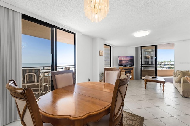 3023 S Atlantic Ave Unit 2050, Daytona Beach, FL 32118 - dining area featuring a wall of windows, a textured ceiling, a chandelier, light tile patterned floors, and a water view