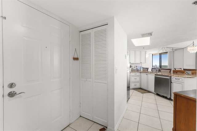 3023 S Atlantic Ave Unit 2050, Daytona Beach, FL 32118 - kitchen with dishwasher, light tile patterned floors, white cabinetry, and a peninsula