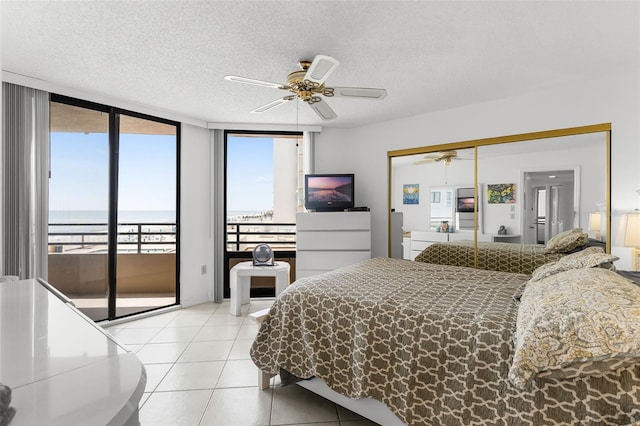 3023 S Atlantic Ave Unit 2050, Daytona Beach, FL 32118 - bedroom featuring access to exterior, a textured ceiling, light tile patterned floors, ceiling fan, and expansive windows