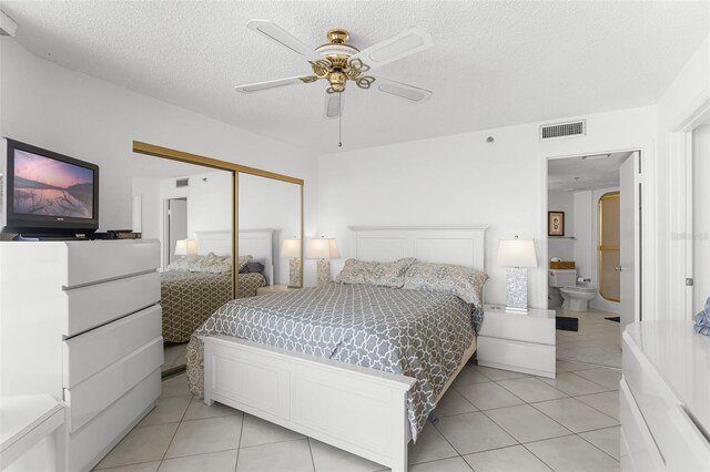 3023 S Atlantic Ave Unit 2050, Daytona Beach, FL 32118 - bedroom with light tile patterned floors, a closet, a textured ceiling, ensuite bathroom, and ceiling fan