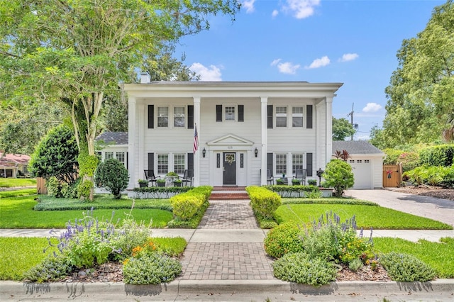 624 Richmond St, Orlando, FL 32806 - greek revival house with a porch, concrete driveway, a front yard, and a chimney