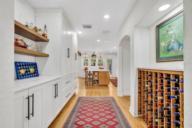 624 Richmond St, Orlando, FL 32806 - wine area featuring light wood-type flooring, arched walkways, and recessed lighting