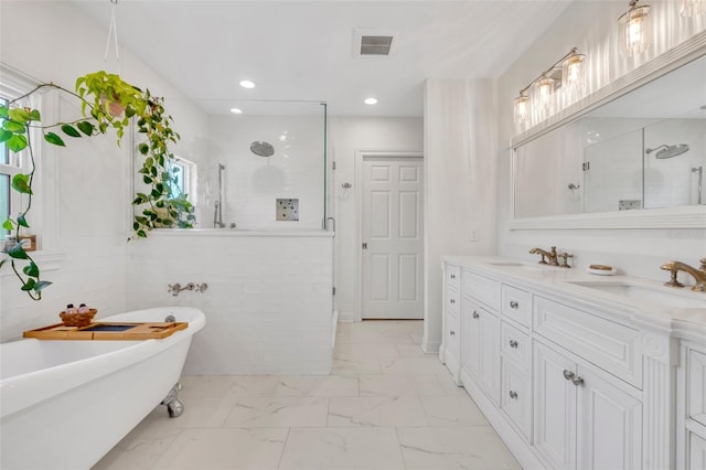 624 Richmond St, Orlando, FL 32806 - bathroom with a walk in shower, double vanity, marble look tile flooring, a freestanding tub, and recessed lighting